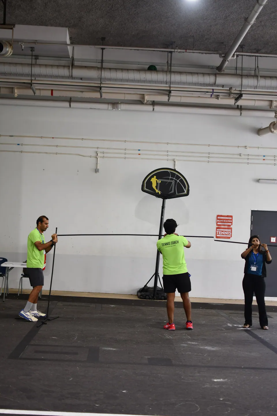 Coaches positioning the frame of an indoor activity station