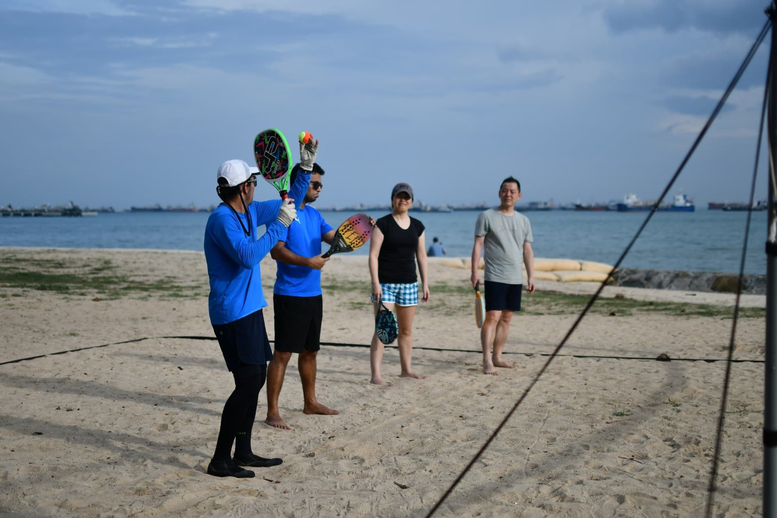 A small team playing beach tennis together