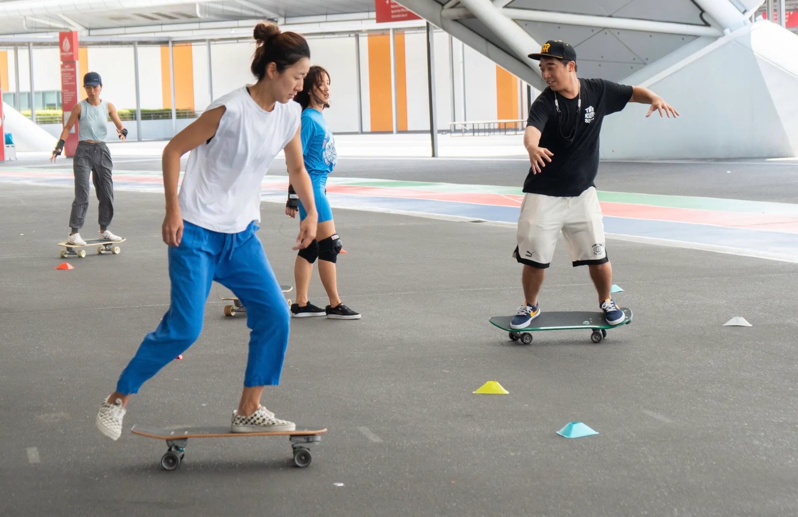 Group skateboarding session with cones on an outdoor court